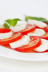 Fototapeta na wymiar Pomidorów i mozzarella plasterki na talerzu