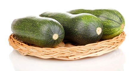 Fresh zucchini on wicker mat isolated on white