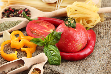 Pasta spaghetti, vegetables and spices, on sacking background