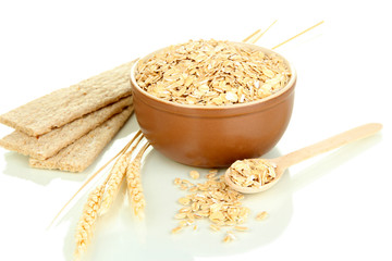 Brown bowl full of oat flakes with spikelets, oat biscuits and