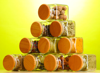 powder spices in glass jars on green background
