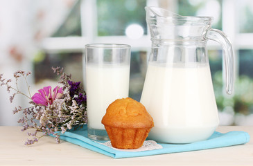 Pitcher and glass of milk with muffins