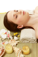 Fototapeta na wymiar A young woman is lying during a spa treatment on a towel