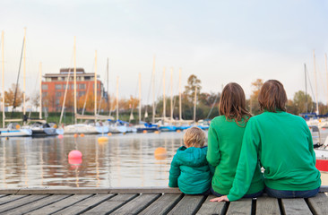 family sitting on pier