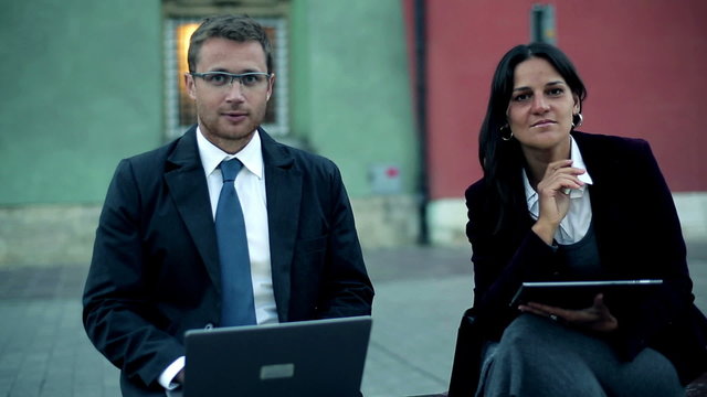 Portrait of smiling business people with laptop and tablet compu