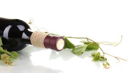 bottle of wine with grape leaves isolated on white