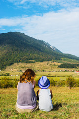 Fototapeta na wymiar woman with child admiring a landscape of mountain