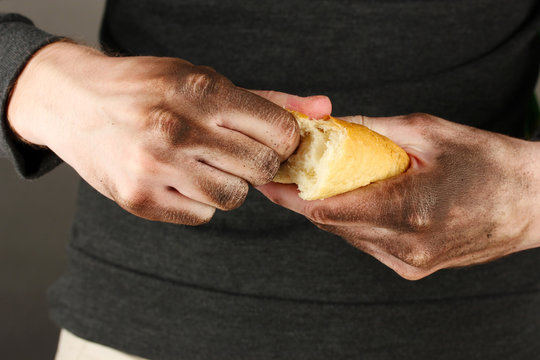 homeless man holding a white bread, close-up
