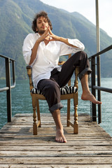 portrait of young man on the armchair near the Lake