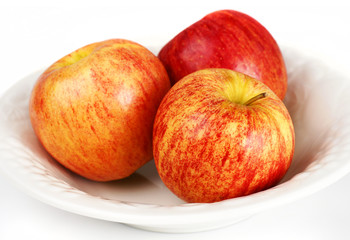 Close-up of three apples in white bowl