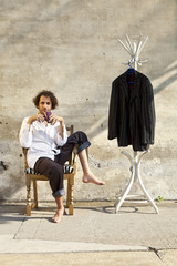 uomo seduto su una sedia in esterno, fuori.