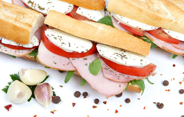 fresh sandwiches with tomato , ham and mozzarella isolated on wh