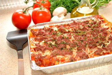 Fresh Ingredients Behind a Pan of Lasagna