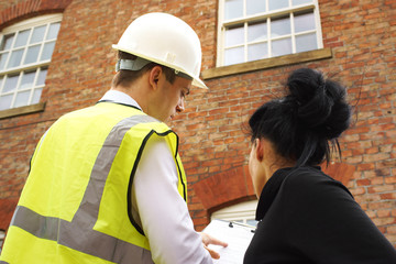 Surveyor or builder and homeowner discussing property issues - obrazy, fototapety, plakaty