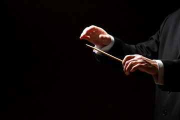 Hands of a conductor isolated on black background - 46142773