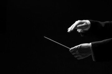 Hands of a conductor isolated on black background - obrazy, fototapety, plakaty