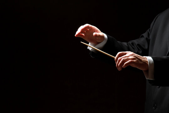 Hands of a conductor isolated on black background
