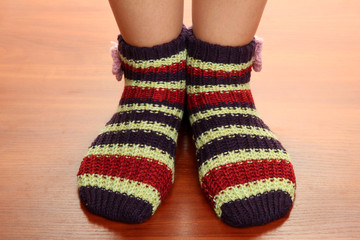 Legs female in striped socks on laminate floor