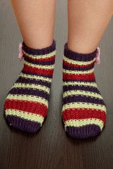 Legs female in striped socks on laminate floor