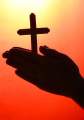 man hands with crucifix, on red background.
