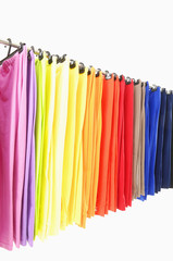 A row of colorful female trousers on hangers