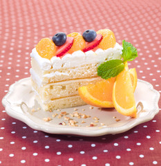 cake topping with fresh orange, strawberry and blueberry