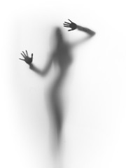 diffuse silhouette of a slim lady, behind a glass surface
