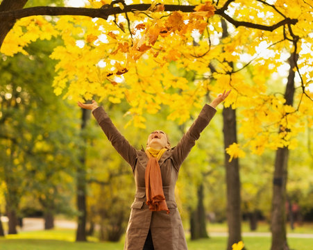 Happy Woman Throwing Fallen Leaves