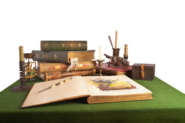 Desk with an open book and old stationery. Isolated on white.