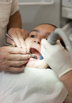 Dentist and his assistant carrying out teeth examination