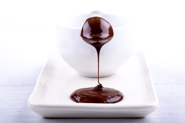 geschmolzene dunkle Schokolade fließt über eine Praline