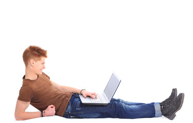 happy man lying down o n floor using laptop