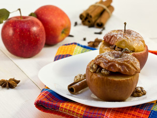 baked apples on a white plate, fresh apples in the background
