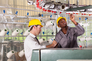 textile factory worker and quality controller checking quality © michaeljung