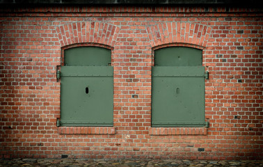 Naklejka premium window in the brick wall and old steel shutters closed