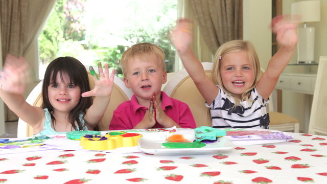 Children Finger Painting Together At Home