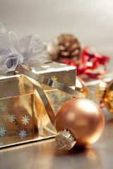 Christmas composition with gift box and bauble, closeup shot