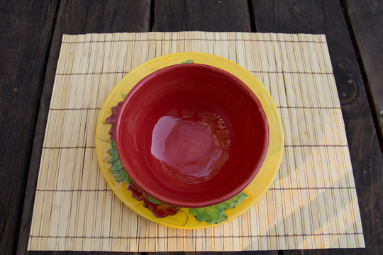 Red ceramic bowl on yellow plate