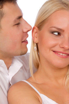 Happy couple in love on white. Man whisper a compliment