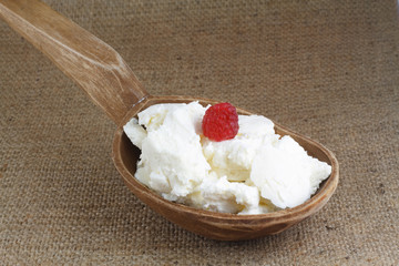 cottage cheese with raspberry on a wooden spoon