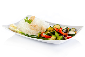 Roasted meat, rice noodles and vegetables on white background