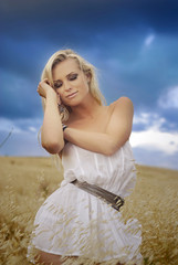Fototapeta na wymiar young beautiful woman in golden wheat field