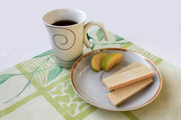 Cup of tea and wafers isolated on green cloth