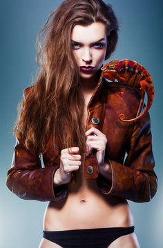 pretty erotic devil woman in leather jacket with chameleon