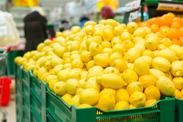 Bunch of lemons and oranges on boxes in supermarket
