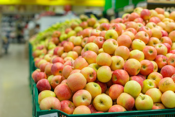 Bunch of red and green  apples on boxes in supermarket