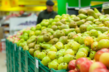 Bunch of green pears on boxes in supermarket