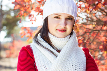 portrait of beautiful young woman in white winter clothes
