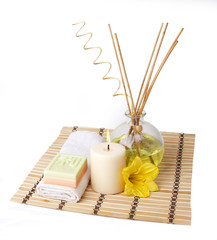 spa setting with aroma sticks and flower on bamboo mat isolated