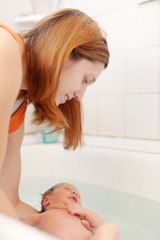 Obraz premium Mother bathes newborn baby